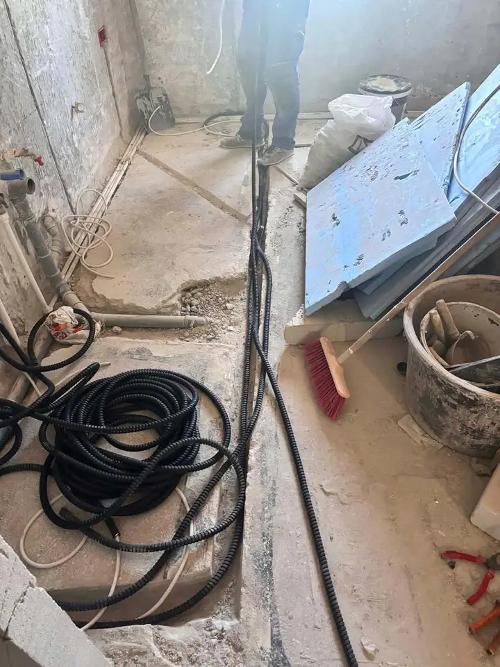 Tuburi flexibile negre pe pardoseală, cu un colac de tub alături